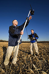 Photo: Two researchers taking measurements of crop residues in a field. Link to photo information
